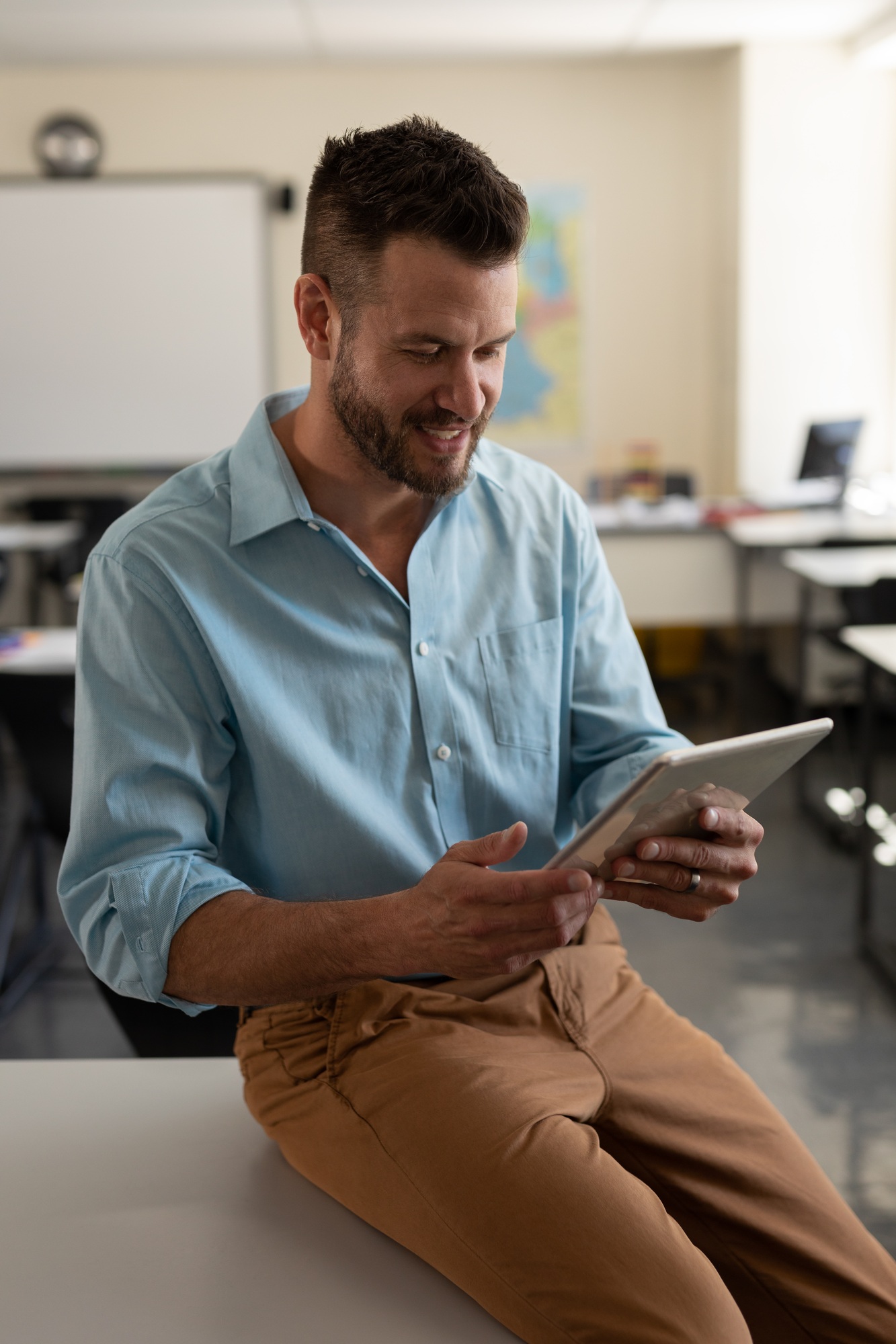 Male teacher using digital tablet in classroom