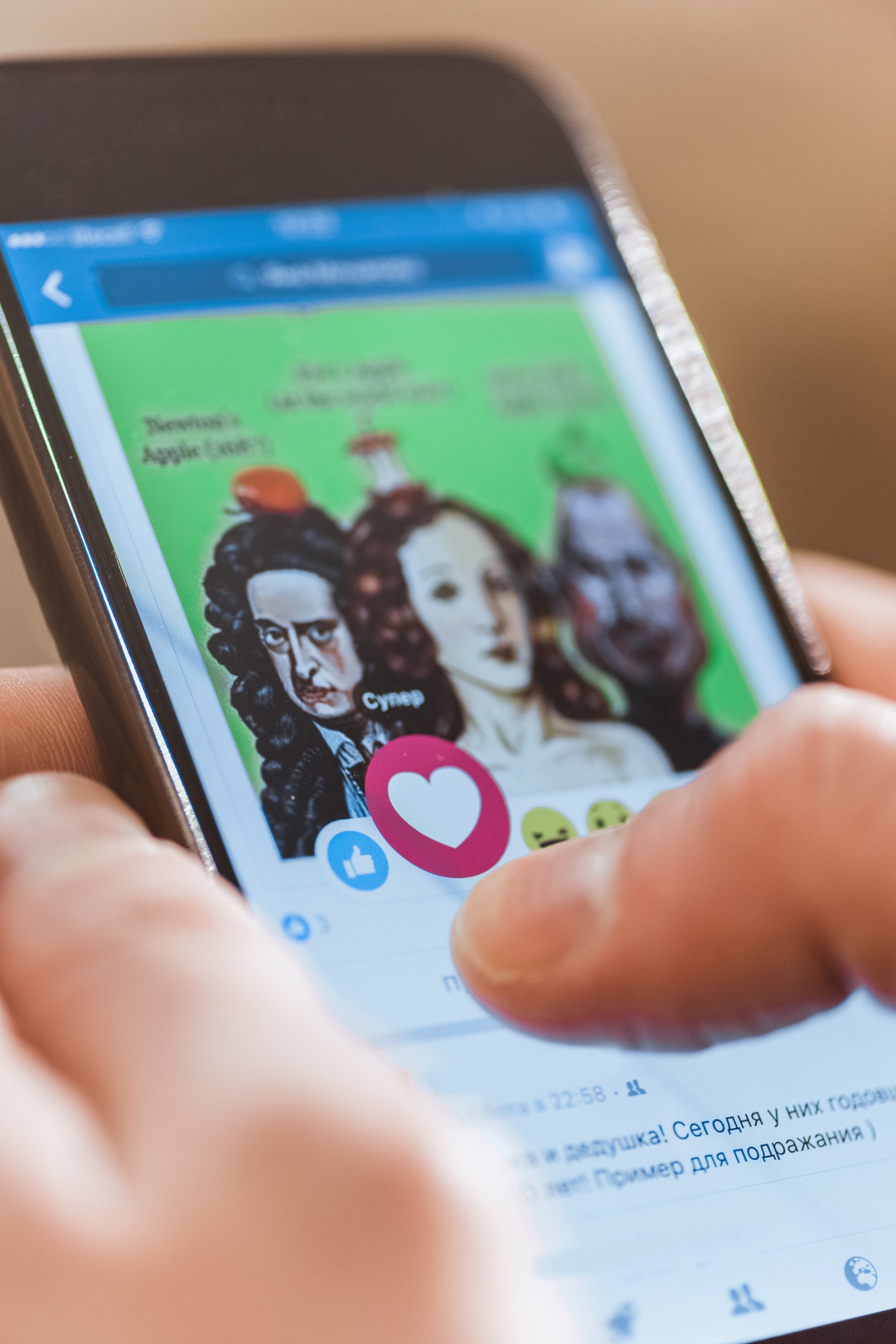 Man using smartphone with facebook application on screen