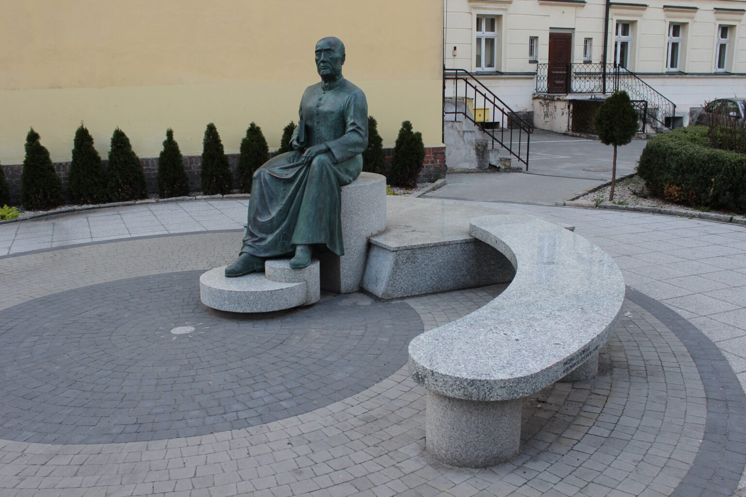 Pomnik księdza Augustyna Szamarzewskiego na ławce w Środzie Wielkopolskiej; wizytówka Google dla firm ze Środy Wielkopolskiej