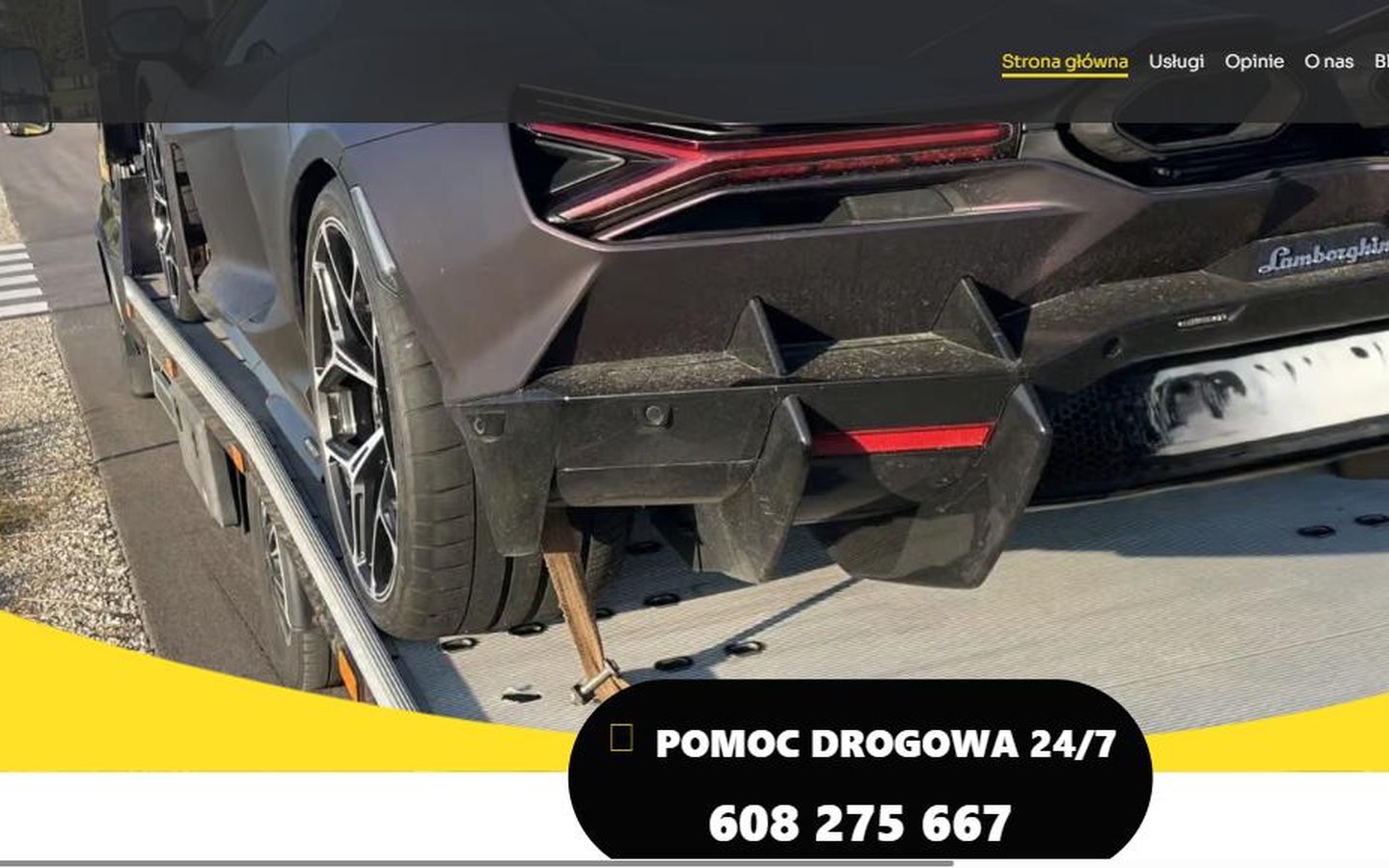 Strona suwalki-pomoc-drogowa.pl — zdjęcie samochodu sportowego na lawecie, żółty akcent i czarna pastylka z numerem telefonu dostępnym całą dobę