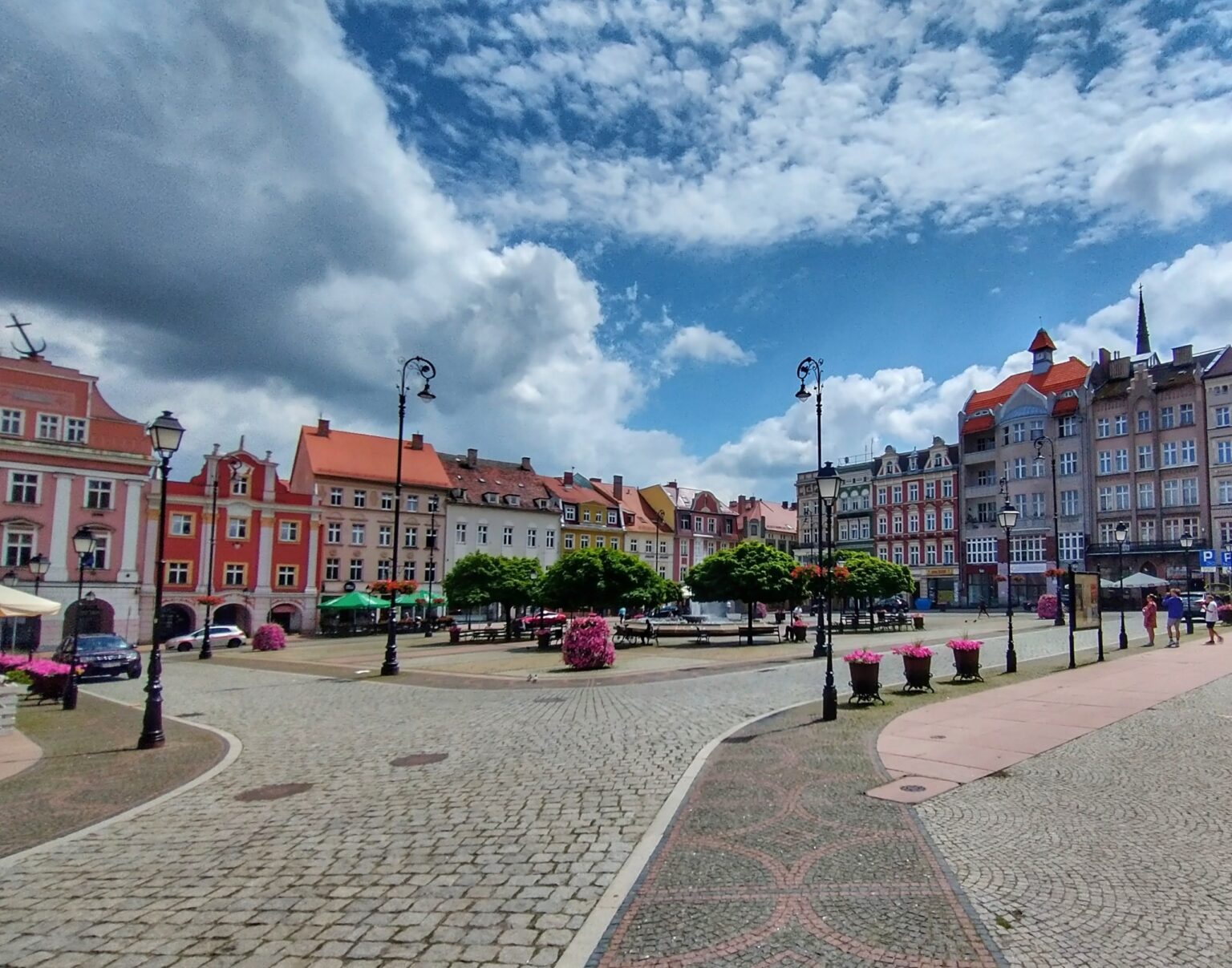 Rynek w Wałbrzychu w słoneczny dzień, kolorowe kamienice i fontanna; pozycjonowanie stron dla firm z Wałbrzycha